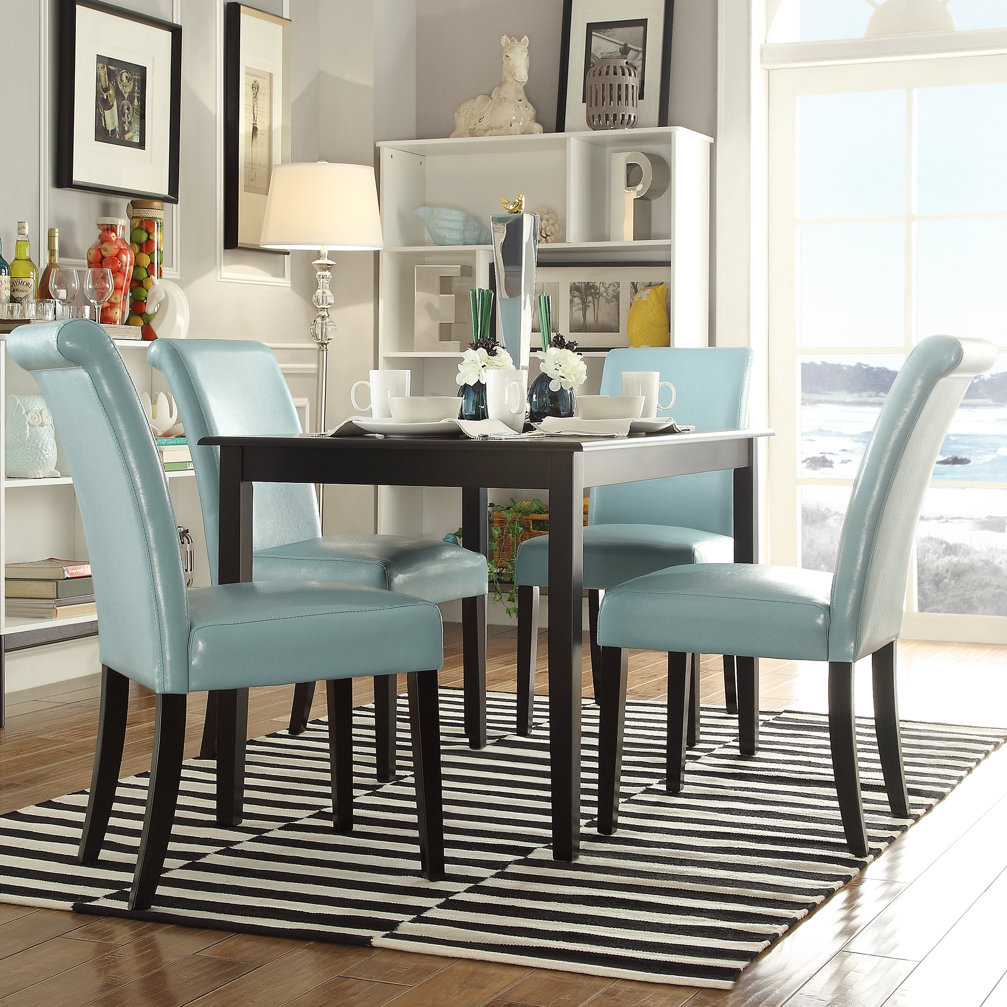 This one of our 10 inspiring dining combinations features a traditional, black wood dining table. The dining table is paired with four parsons chairs, which are upholstered in light blue faux leather and have black wood legs.