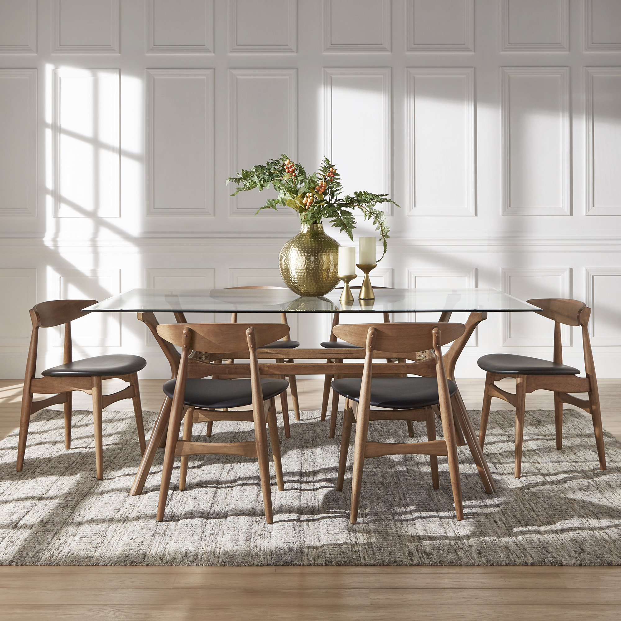 This is a mid-century modern inspiring dining combination. Taking cues from Scandinavian style, this set includes a glass top rectangular dining table. The dining chairs have curved backs, natural wood grain finishes, and black upholstered seats.