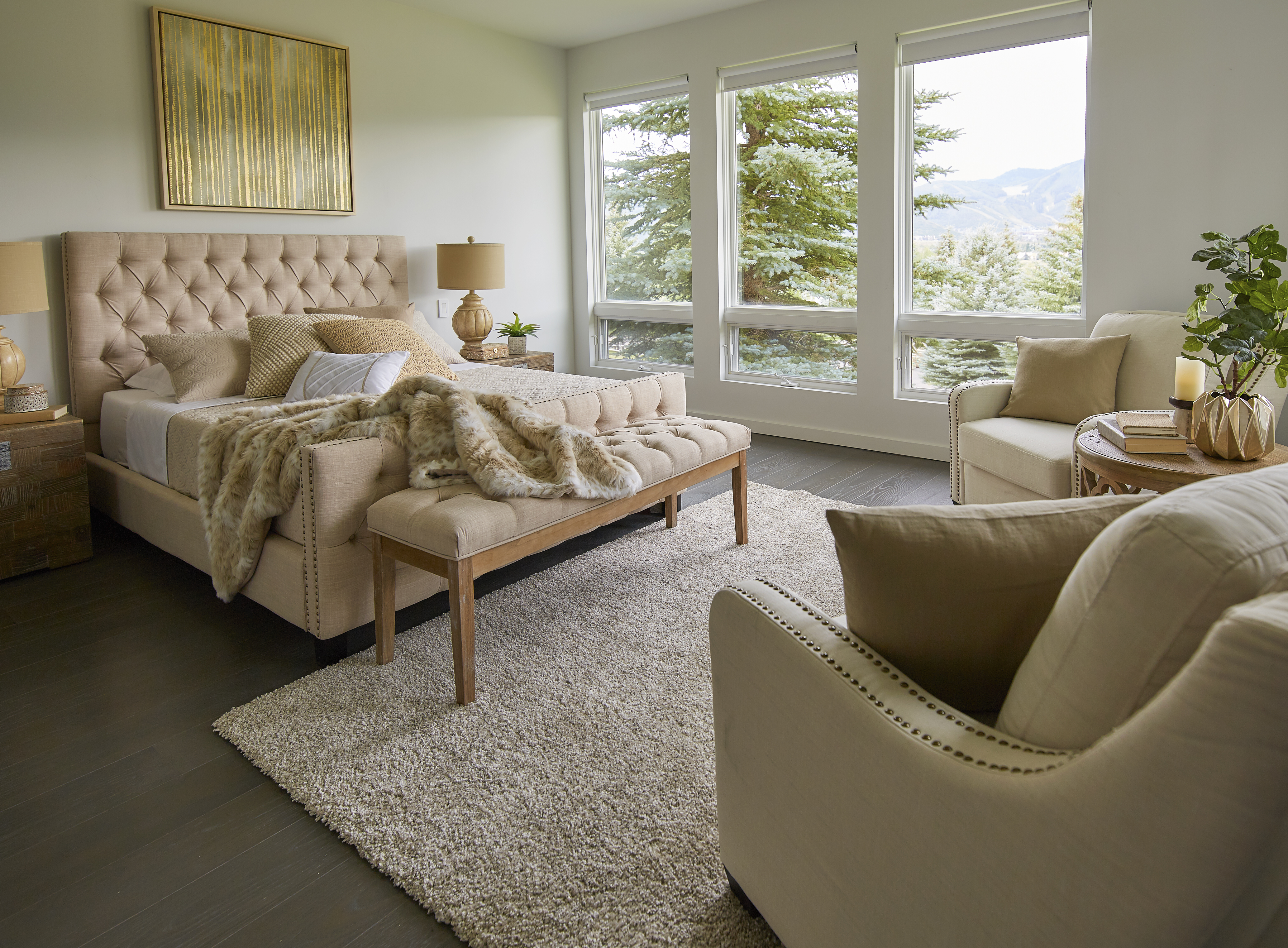When looking at the different ways on how to make your guests feel right at home, it's all about delivering comfort. This image depicts just that with a Button Tufted Beige Linen Upholstered Bed, Button Tufted Beige Line Upholstered Bench, and two beige linen upholstered accent chairs.