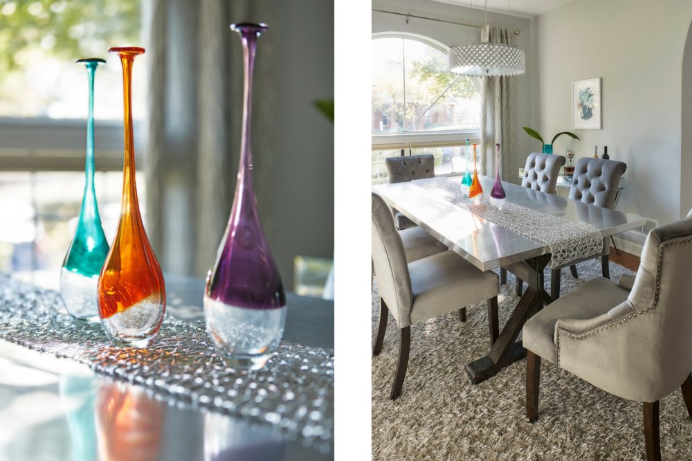 Two images are displayed here, both of which focus on our Illinois home makeover dining room. The left image is a close-up of the stainless steel top of the dining table, with a silver table runner and three colorful glass vases. The image on the right shows another view of the dining room. It includes the stainless steel top dining table with espresso wood trestle base, grey velvet button tufted parsons chairs, and grey velvet button tufted wingback hostess chairs.
