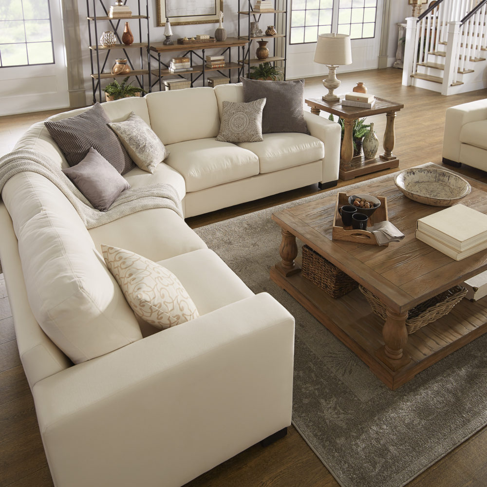 Another angle of the classic-styled space. The white fabric sectional sofa has its previous throw pillows of various shades of grey, white, and yellow.