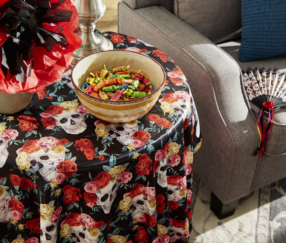Pictured is our Day of the Dead-themed end table with a close-up shot on the bowl filled with colorful Tootsie Roll candies.