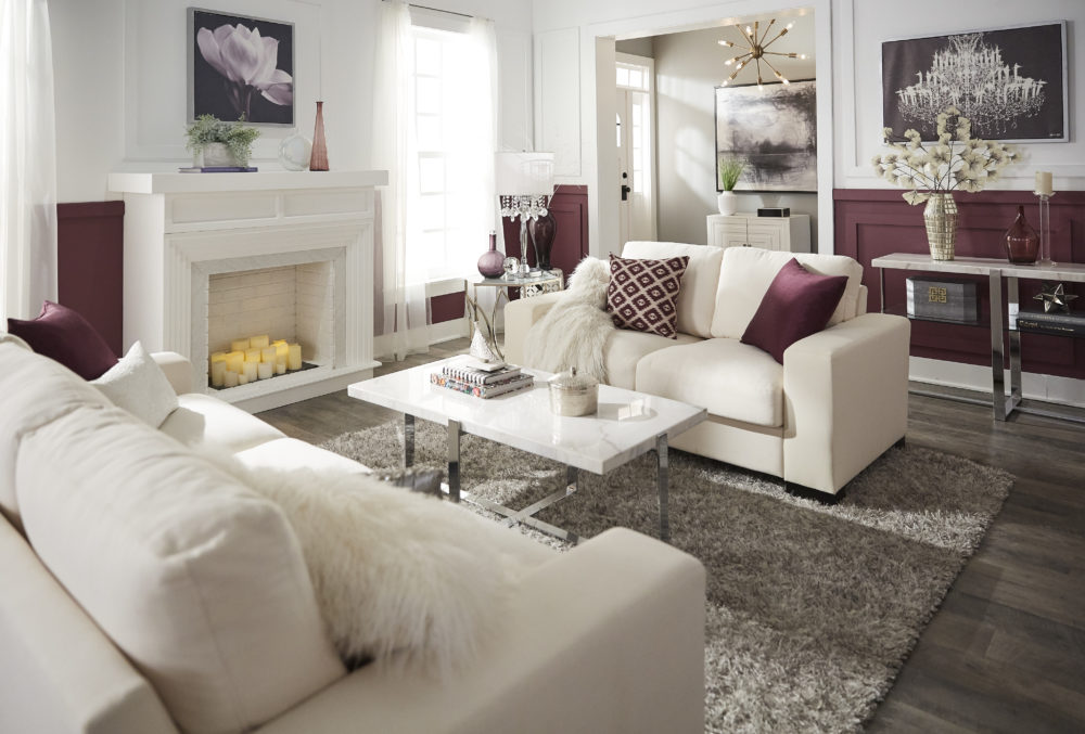 Glam designed living room with white couch, purple pillows and marble tables