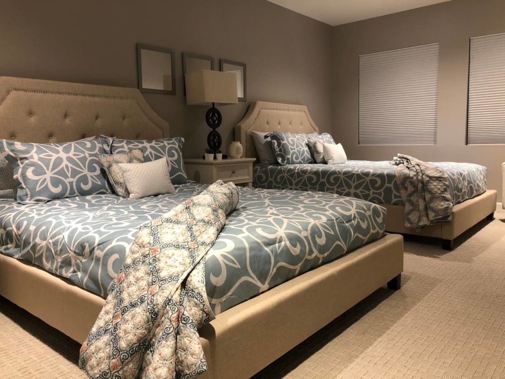 Two iNSPIRE Q beige upholstered tufted beds in bedroom of North Carolina Airbnb.