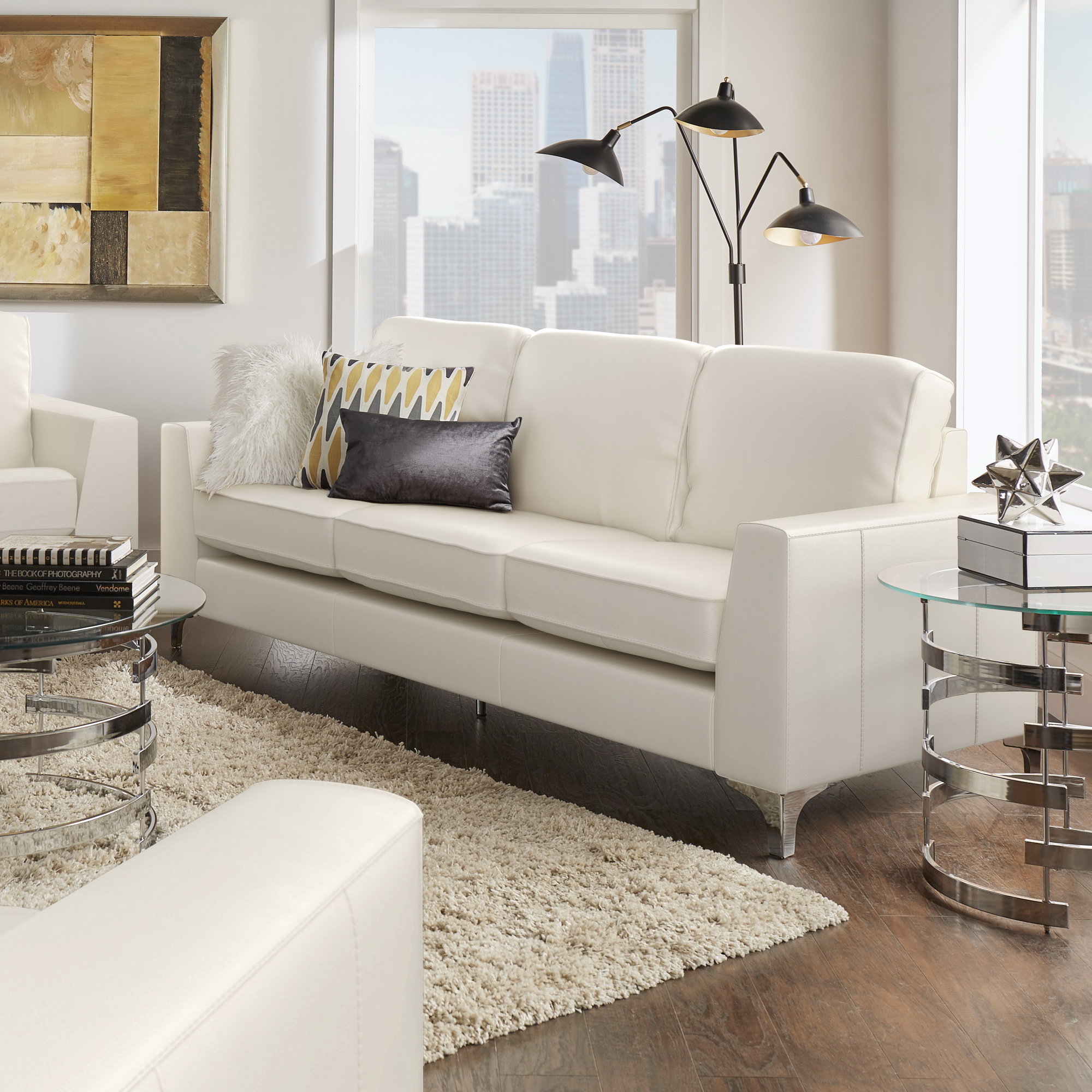 As we move into discussing real leather among furniture materials, this image showcases aniline leather. The focus of this image is the White Aniline Sofa by iNSPIRE Q Modern. This unique sofa is founded on chrome-finished bracket feet for some added glam.